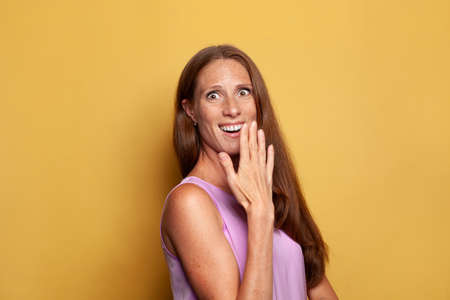 Funny cute stylish cool surprised woman on yellow background, lifestyle portraitの写真素材