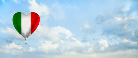 Italian flag on balloon against sky clouds background. Education, charity, emigration, travel and learning Italian language, Italy conceptの写真素材