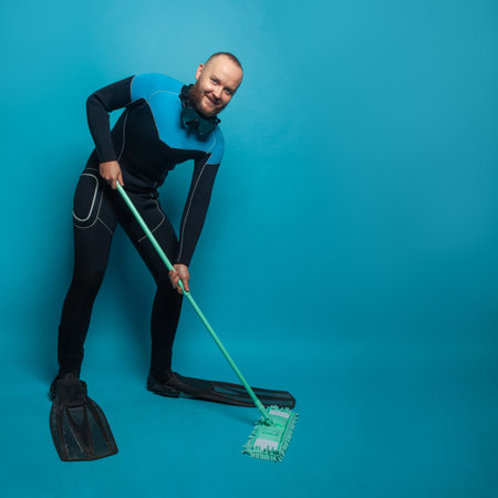Happy man diver with mop on blue banner background. Clean and environmental protection concept.の写真素材