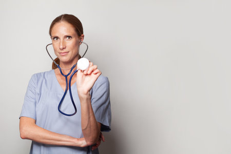 Middle age adult nurse or doctor woman with stethoscope looking at the camera. Positive person.の写真素材