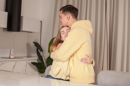 Beautiful couple in yellow clothes huggingの写真素材