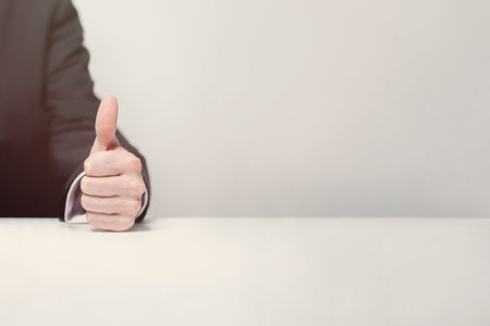 Business person in suit showing thumb up, business win conceptの写真素材