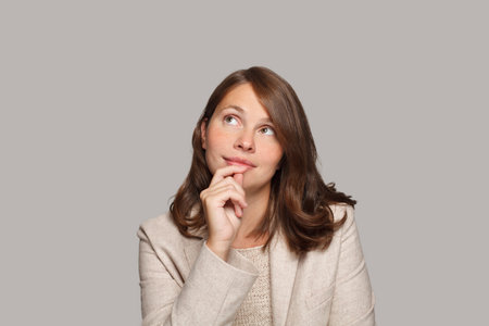 Beautiful business woman thinking, looking up and smiling. Idea conceptの写真素材