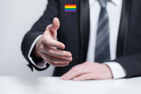 Businessman with little LGBT sign in suit, handshake. Partnership, deal and agreement conceptの写真素材