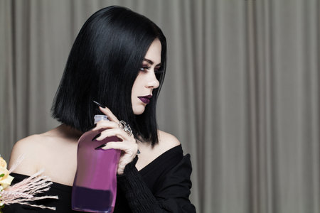 Beautiful brunette woman holding bottle with blank label for advertisingの写真素材