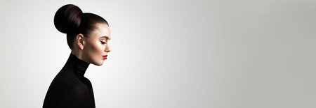 Fashion beauty portrait of perfect glamorous young adult woman brunette model with makeup and perfect hairdo posing against white studio wall banner backgroundの写真素材