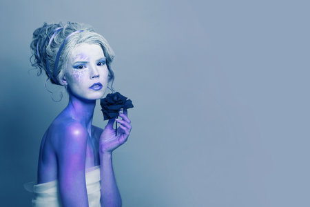 Beautiful woman with fantasy makeup on blue backgroundの写真素材
