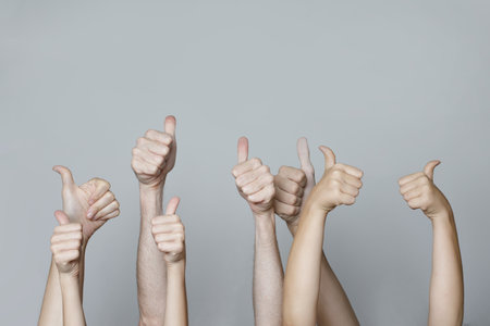 Many people congratulate a winner and holding their thumbs up. Human hands with thumb upの写真素材