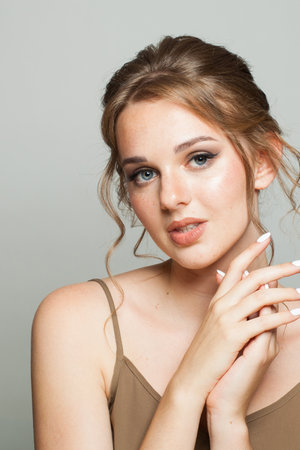 Attractive good-looking woman with updo hairstyle and makeup. Young female model portrait