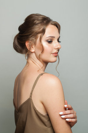 Lovely good-looking woman with updo hairstyle and makeup. Young female model portrait
