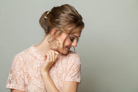 Elegant hairstyle of a young woman in a lace dress.