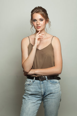 Healthy fashion model woman standing against white studio wall backgroundの写真素材