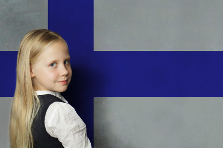 Happy blonde young child girl an Finnish flag background. Education in Finland and study Finnish language conceptの写真素材