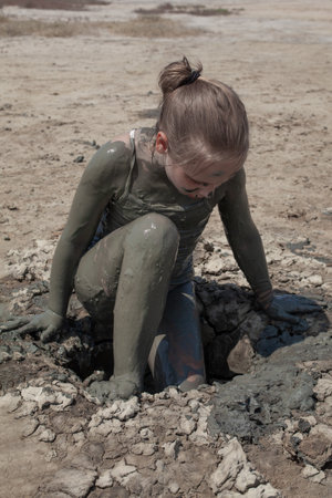 Dirty kid on mud geyser resort outdoor