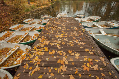 Empty wooden pier and boat on lake. Autumn landscape backgroundの写真素材