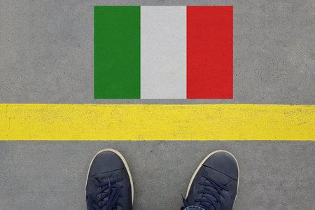 Word Start on an asphalt road with the Italian flag and legs in shoes. Travel in Italy conceptの写真素材