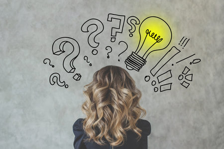 Female head and back with light bulb on gray backgroundの写真素材