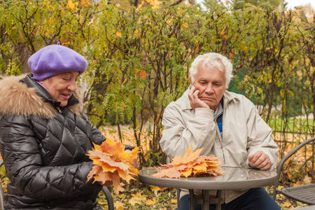 Portrait of senior couple in autumn park outdoorの写真素材