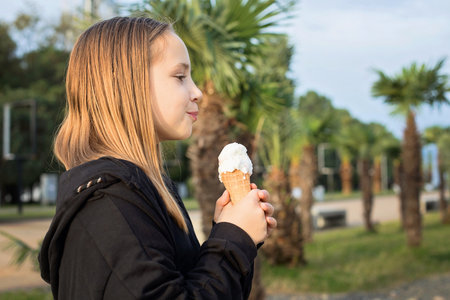 Child enjoying eating an ice cream in cone, portraitの写真素材