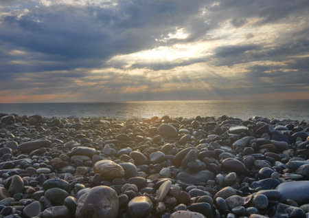 Beautiful landscape of sea, sunset and pebble beachの写真素材