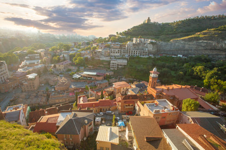Beautiful sunny landscape of Tbilisi and green mountains on the background of cloudy skyの写真素材