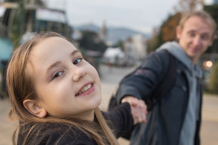 Pretty daughter child girl and her father having fun. Happy family outdoors portrait. Happiness, childhood and bonding conceptの写真素材