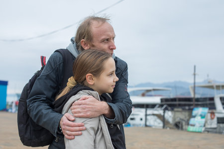 Father hugging his daughter child girl outdoors. Happy family outdoors portrait. Happiness,...