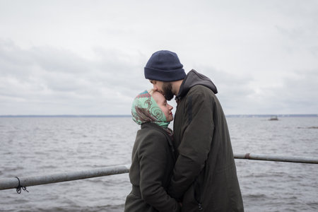 Young man and woman couple hugging each other kissing at seasideの写真素材