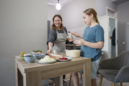 Female family indoor. Mother And Daughter Baking Pizza In Kitchen Togetherの写真素材