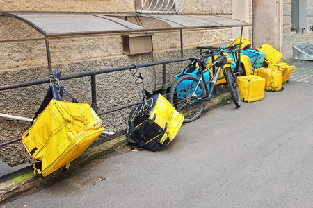 Yellow and blue delivery backpack on empty streetの写真素材
