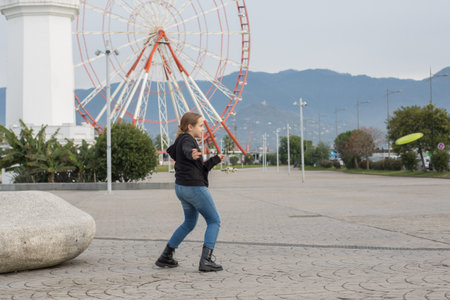 Happy child young girl throwing flying disc and having fun outdoors. Happy childhood, sport and leisure activity conceptの写真素材