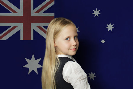 Beautiful young child girl on flag of Australia background. Education in Australia conceptの写真素材