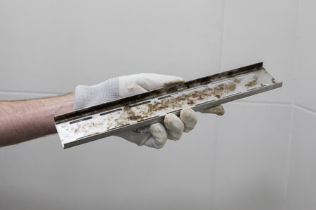 Plumber holding Stained Water Drain on Gray Backgroundの写真素材