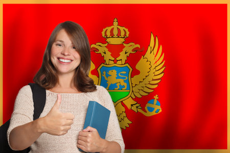 Positive woman student against flag of Montenegro background. Travel, education and learn language conceptの写真素材