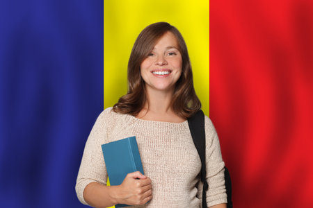 Successful woman student against Romanian flag background. Travel, education and learn language in Romania conceptの写真素材