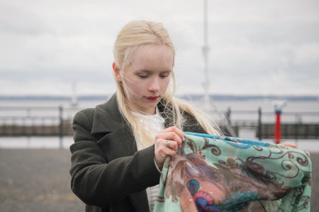 Pretty blond woman with headscarf standing outdoorsの写真素材
