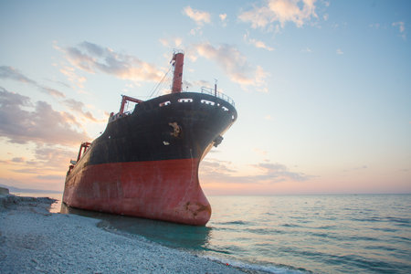 Large cargo ship near coastline at sunset after a stormの写真素材