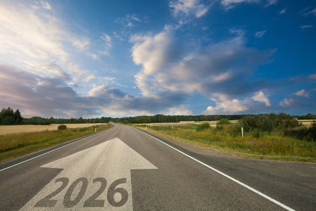 2026 New Year road trip. Nature landscape with highway road leading forward to happy New Year...