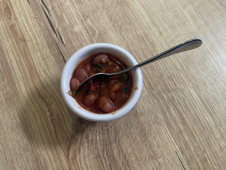 bowl of beans isolated on wooden tableの写真素材