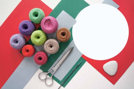 yarns of threads for knitting in different colors on a red green background の写真素材