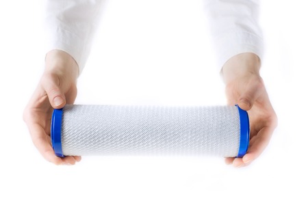 water filter cartridge in human hands isolated on whiteの写真素材