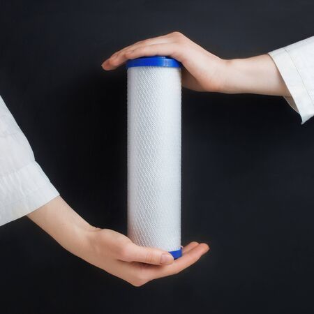 water filter cartridges in human hands on blackの写真素材