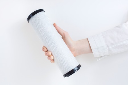 water filter cartridge in human hands on whiteの写真素材
