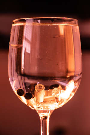 Empty bullet cartridges resting at the bottom of a wine glass like ice cubes
