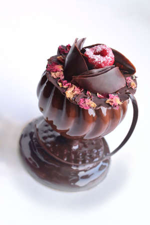 Glass shaped dessert with rose petals and raspberry on white backgroundの写真素材