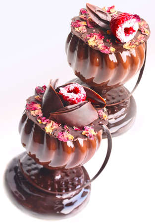 Glass shaped desserts with rose petals and raspberry on white backgroundの写真素材
