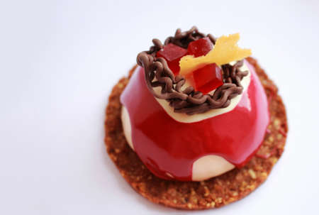 Red and white dessert with chocolate decoration, red jelly and cookie baseの写真素材