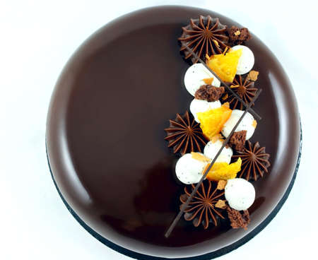Chocolate and orange cake with chocolate ganache stars and whipped cream on white background top viewの写真素材