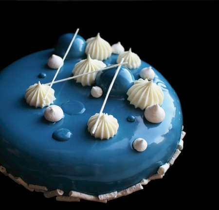 Blue and white cake with white chocolate and mirror glaze isolated on black backgroundの写真素材