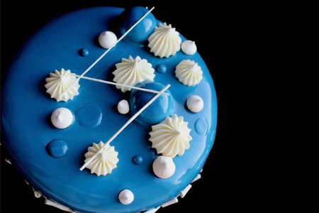 Blue and white winter cake with white chocolate ganache and mirror glaze isolated on black background top viewの写真素材